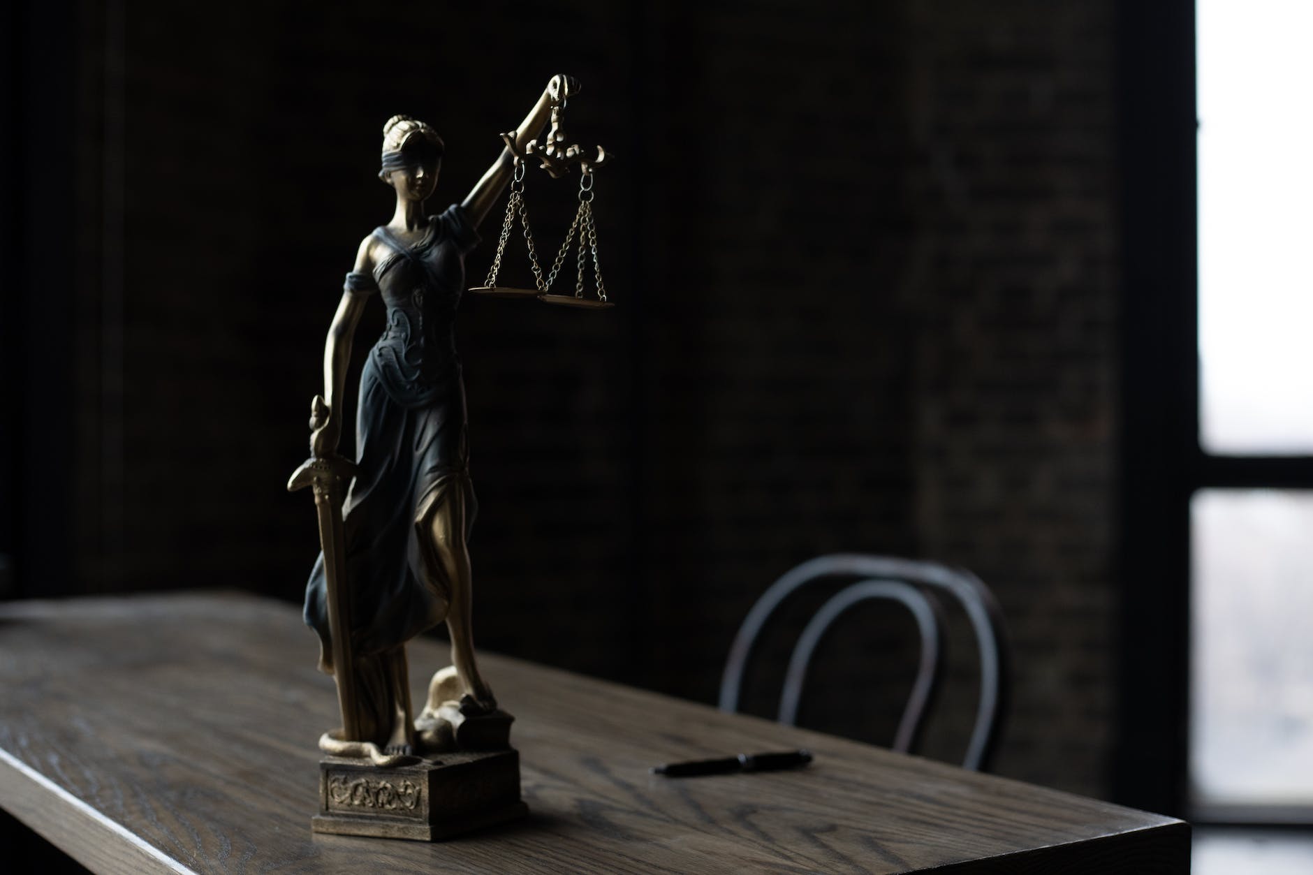 a figurine of the lady justice on a table legislation